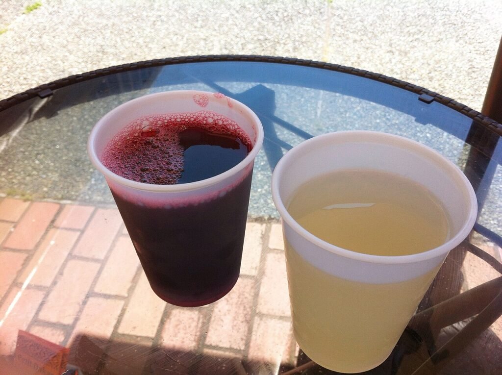Freshly squeezed ginger juice (right) ready for ginger shots, beside a bissap drink