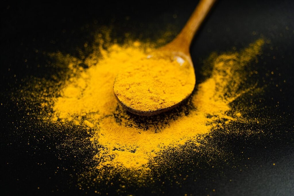 Turmeric powder on a spoon for golden milk recipe