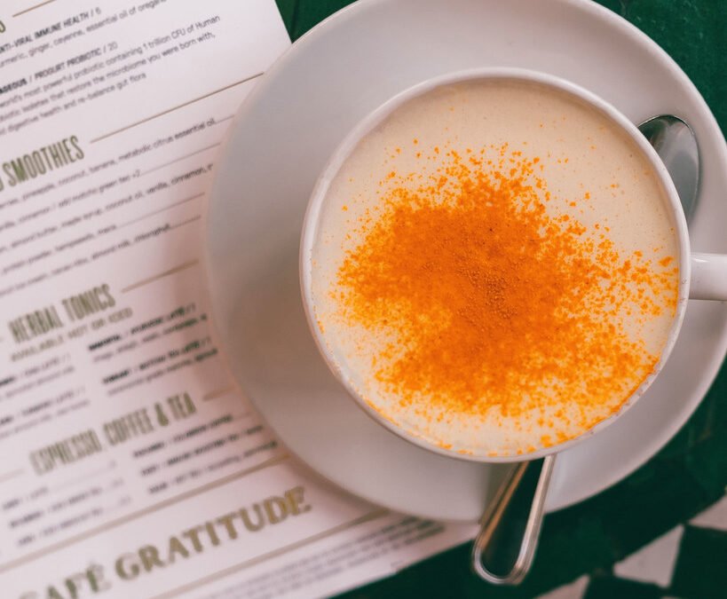 Creamy turmeric latte (golden milk) in a glass cup